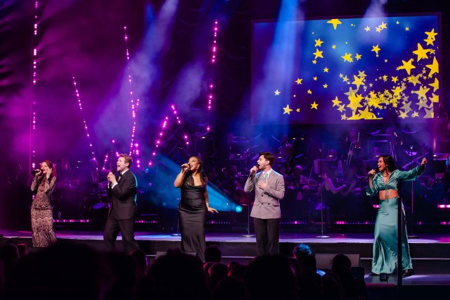 A row of performers on stage