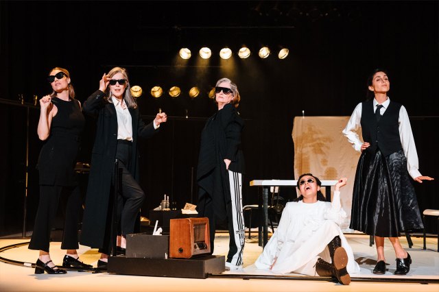 Five actresses of various ages, gathered on a stage, wearing sunglasses