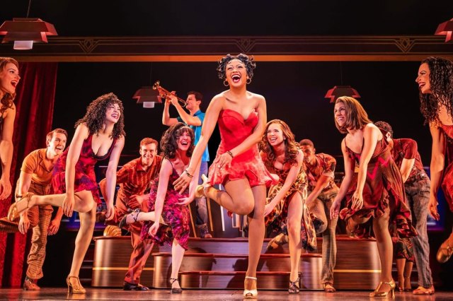 An actress, dressed as Betty Boop, dancing on stage, surrounded by an ensemble of actors