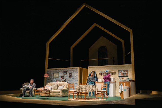 Trois acteurs debout sur un salon sur scène.