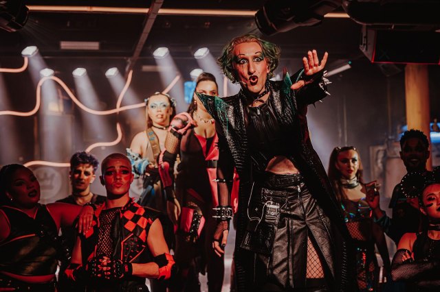 An actor in a dystopian costume in a nightclub setting