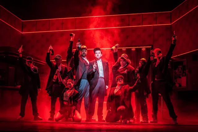 Samuel Holmes (au centre) dans le rôle de Sir Charles Denbigh et le casting de BANK OF DAVE, crédit Marc Brenner
